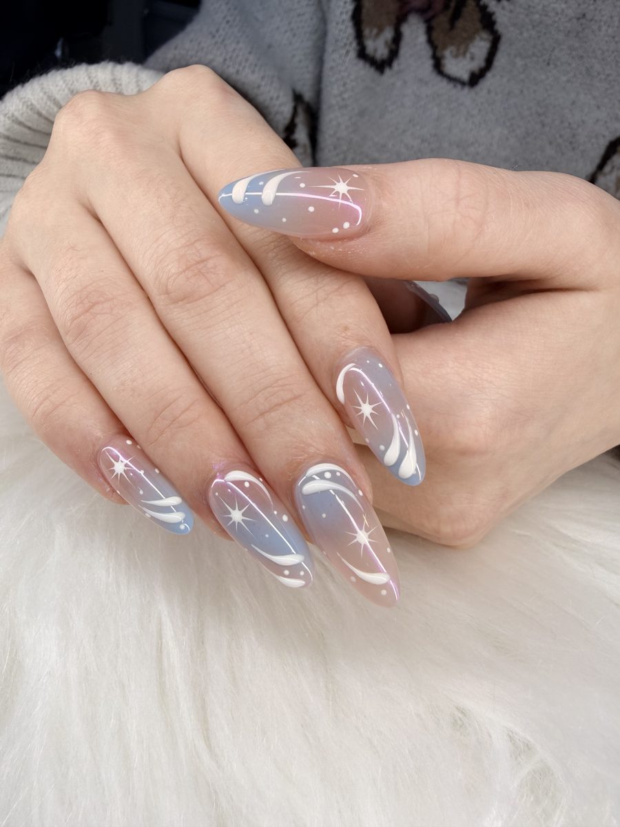 Sheer almond nails with icy blue swirls and silver sparkle