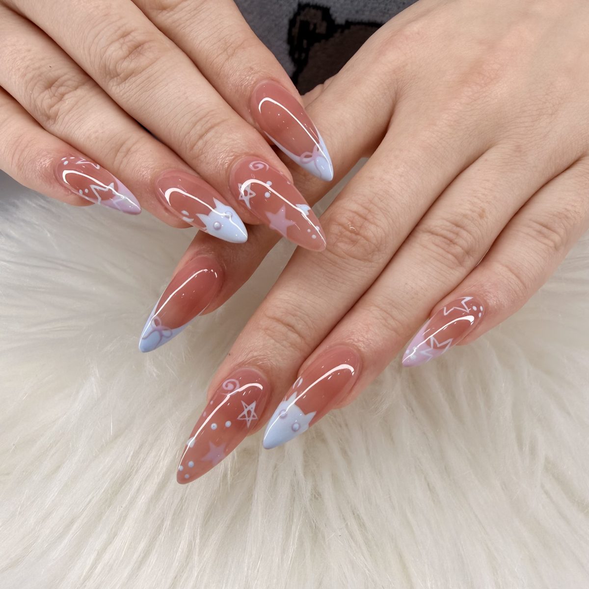 Long sheer pink almond nails with white swirl and marble accents