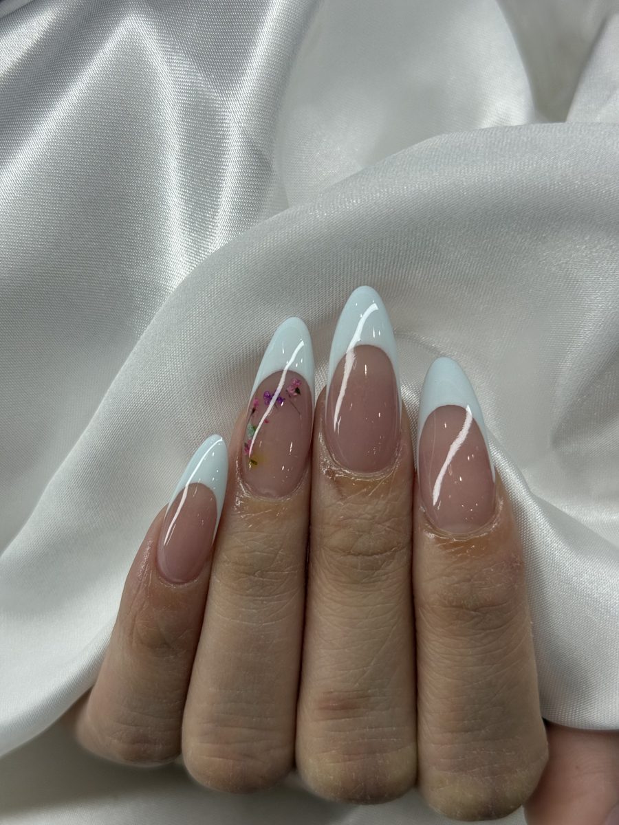 Classic white French tips on long almond nails over white satin