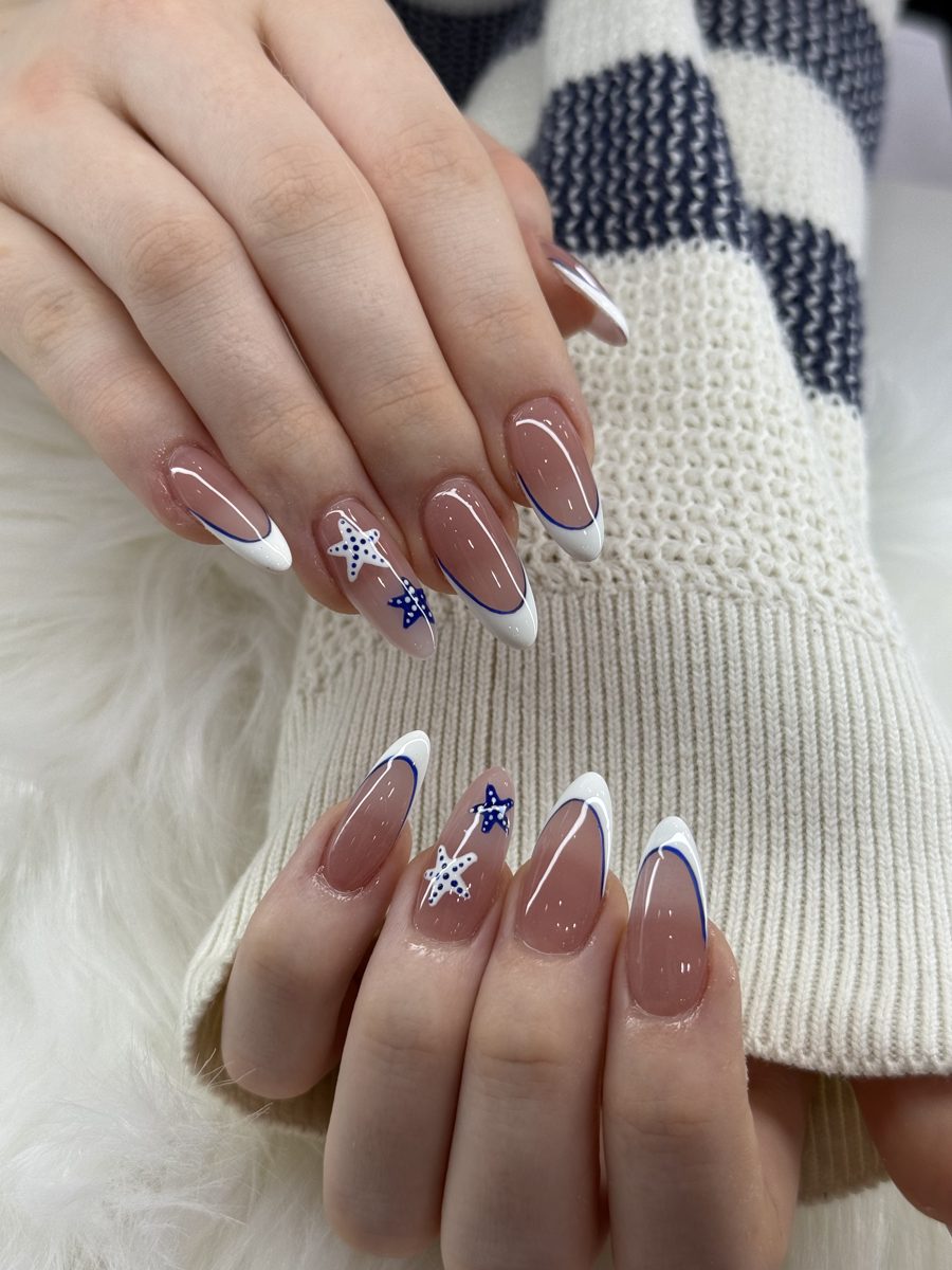 Almond nails with white French tips and blue snowflake accents